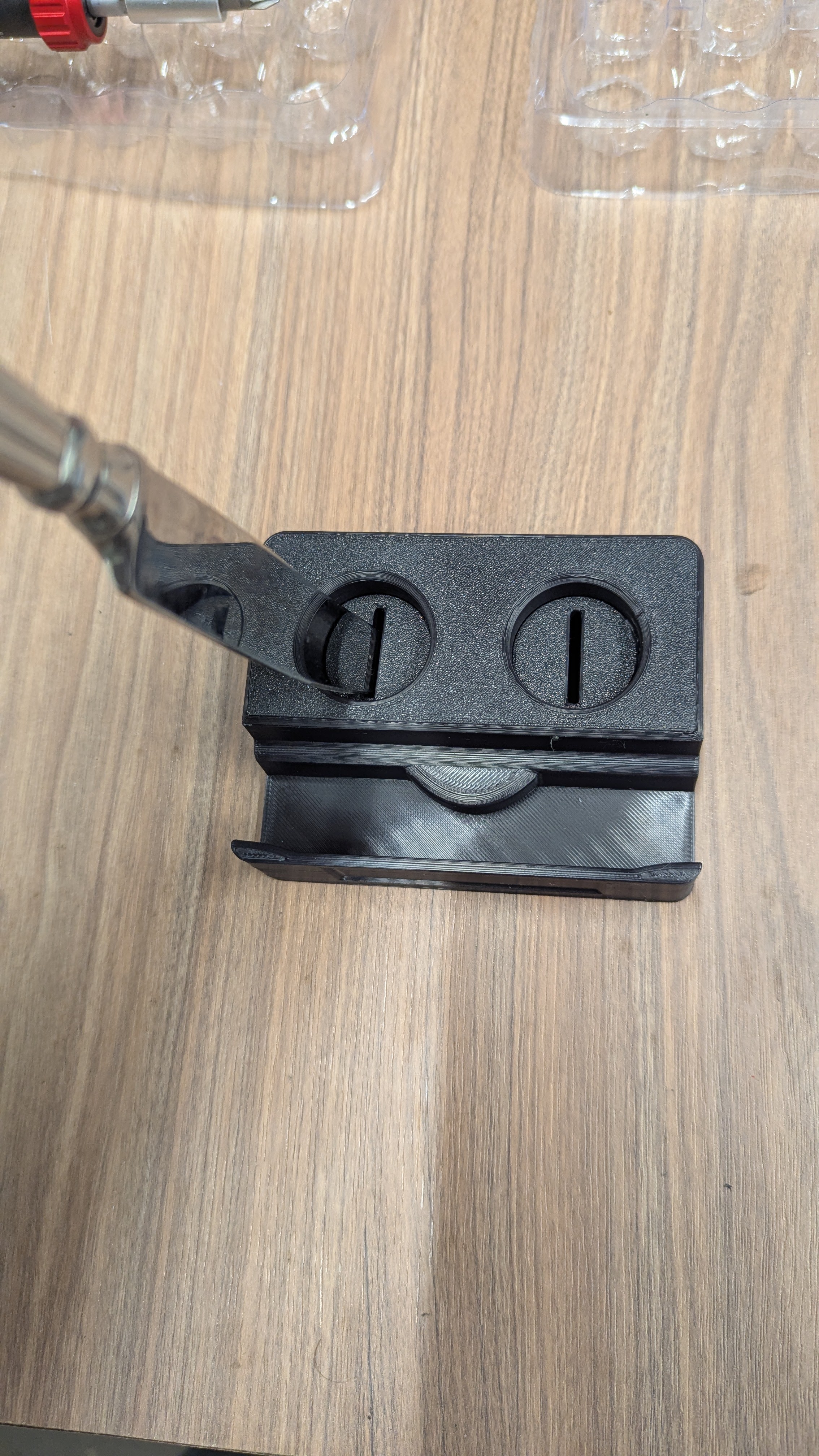 Using butter knife to adjust owl eyes on base station showing clockwise and counterclockwise directions